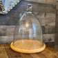 Tall glass dome with round wood serving board