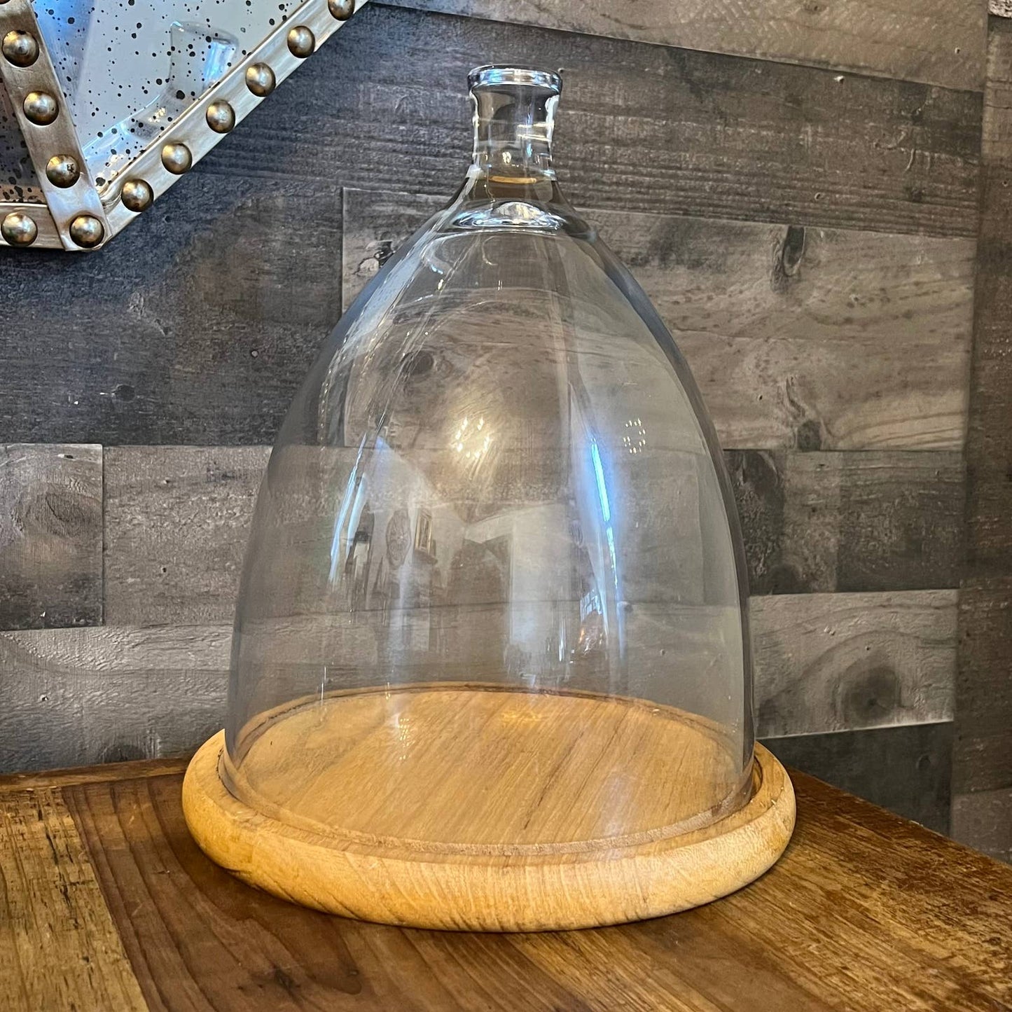 Tall glass dome with round wood serving board