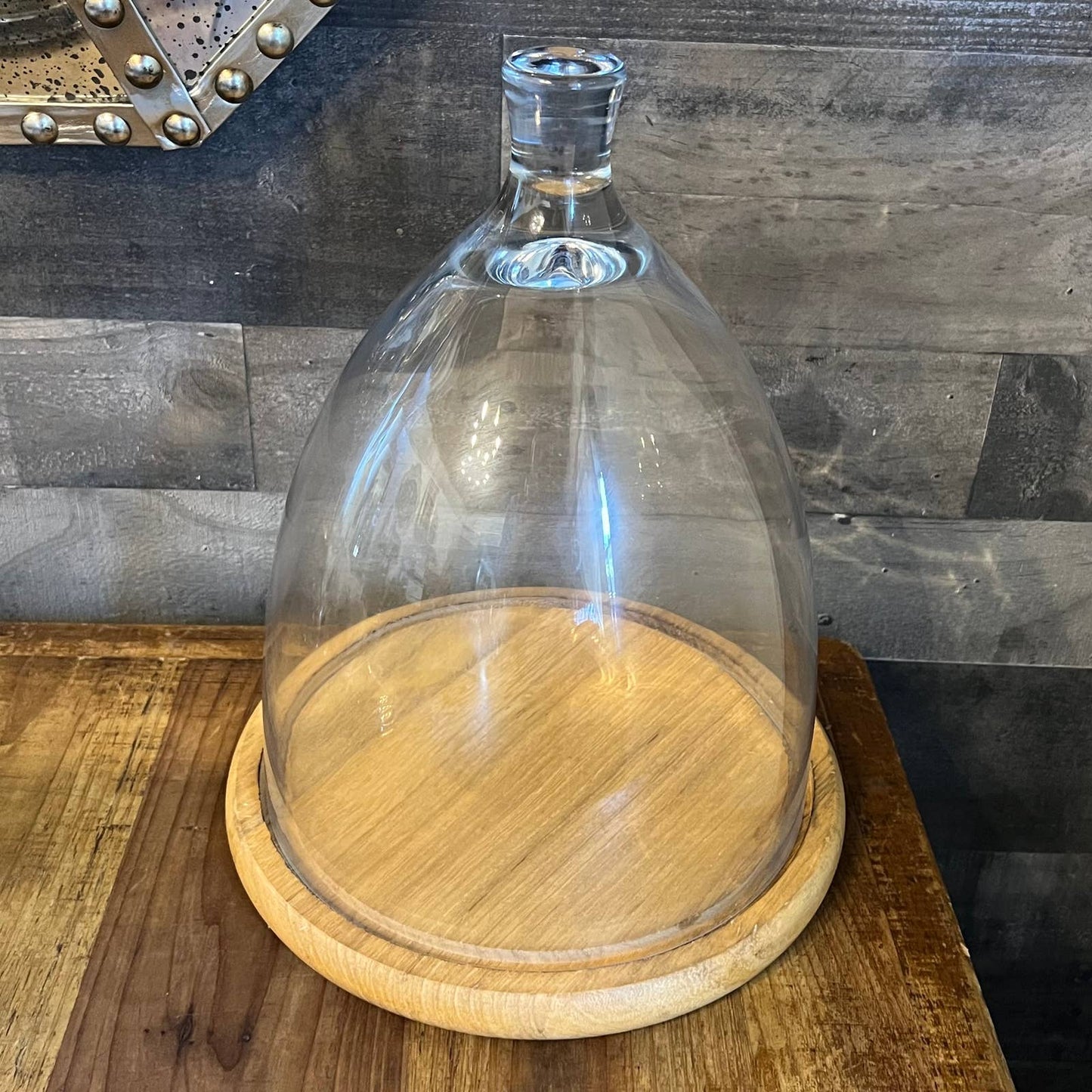 Tall glass dome with round wood serving board