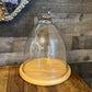 Tall glass dome with round wood serving board